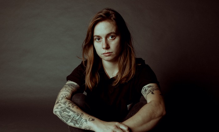 Julien Baker sitting and looking at the camera
