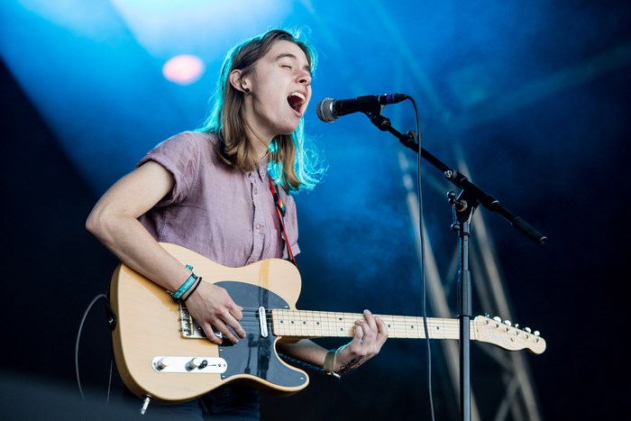 Julien Baker performs on stage with a guitar