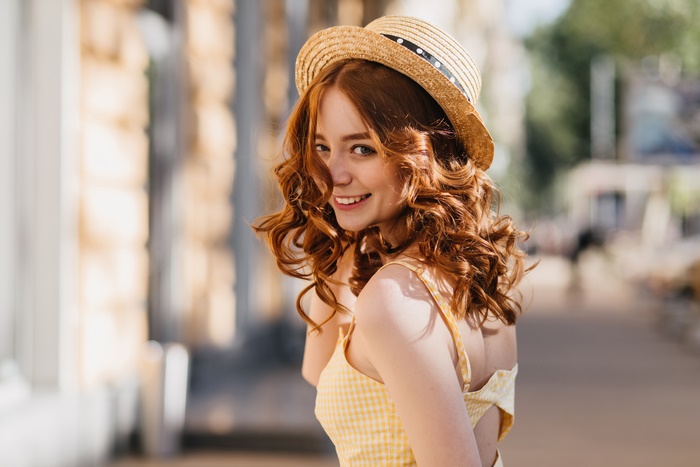 Redhead woman in a straw hat smiling