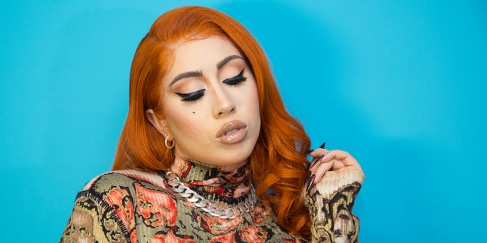 Kali Uchis with orange hair and patterned shirt
