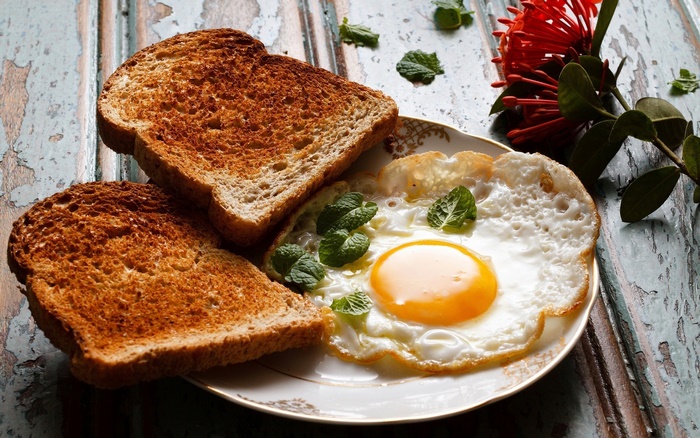 Fried egg with toast and mint leaves