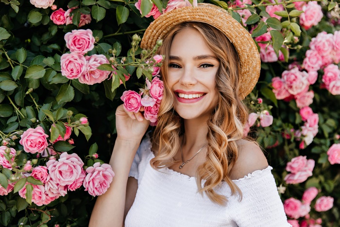 Woman in Straw Hat Poses with Pink Roses