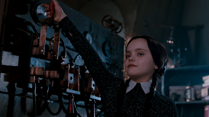 Wednesday Addams operating a complex machine