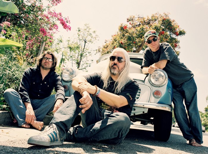 Dinosaur Jr. band members sitting by a car
