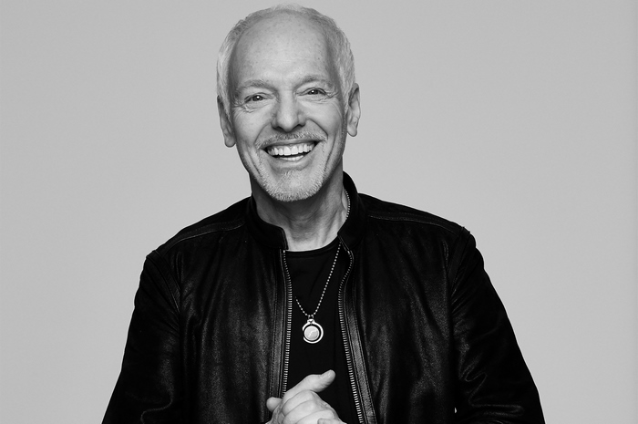 Peter Frampton smiling in a black leather jacket