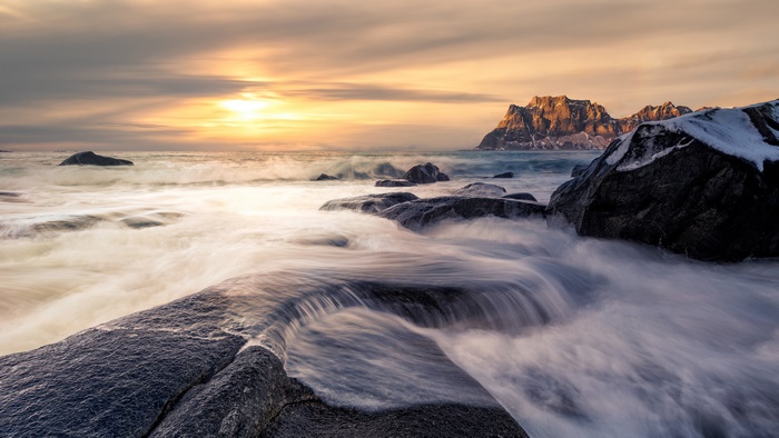 Norway 4K: Ocean waves crashing on rocky shore at sunset