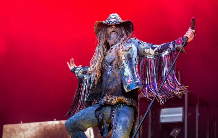 Rob Zombie performs on stage with red background