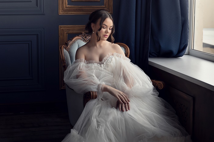Woman in a white wedding dress sitting in a chair