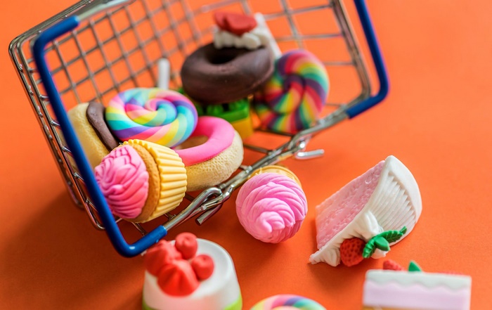 Miniature candy and sweets in a shopping cart
