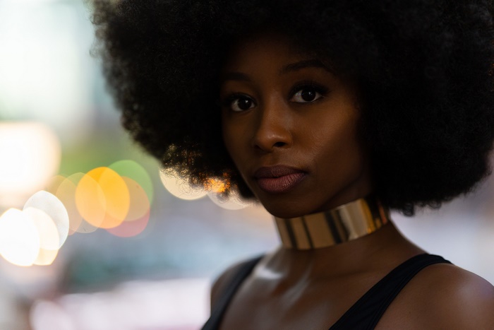 Woman with afro and gold choker