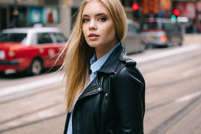 Blonde woman in leather jacket on city street