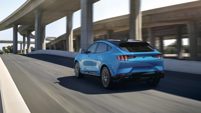 Blue Ford Mustang Mach-E GT driving on a highway