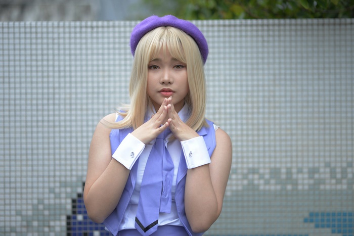 Asian woman with blonde hair wearing a purple hat