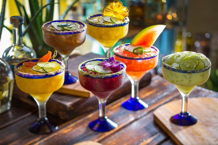Assortment of colorful margaritas on a wooden table