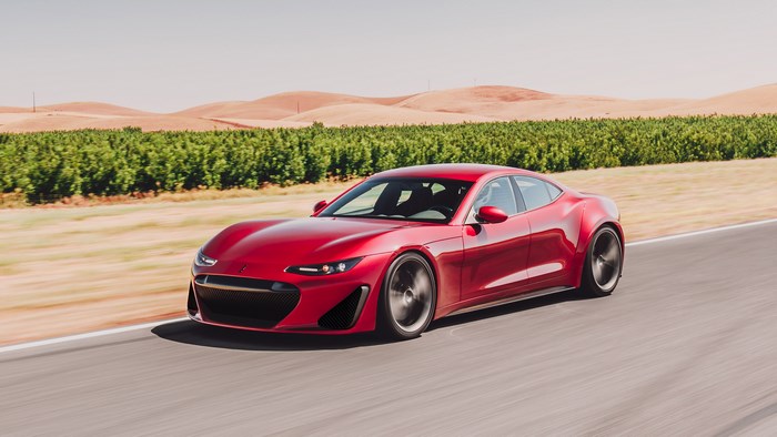 Red Drako GTE driving on a road