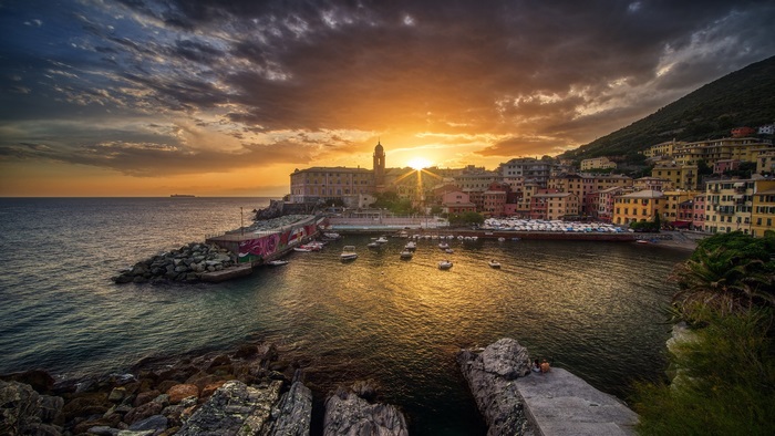 Coastal town at sunset with boats in the harbor