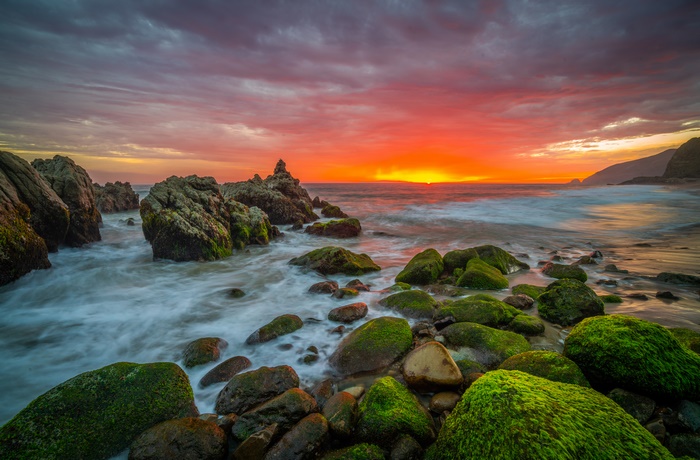 Sunrise over the ocean with rocks in California