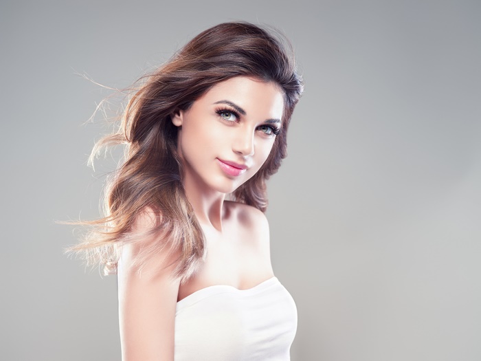 Model with flowing brown hair and makeup