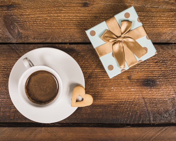 Coffee and a gift box on a wooden table
