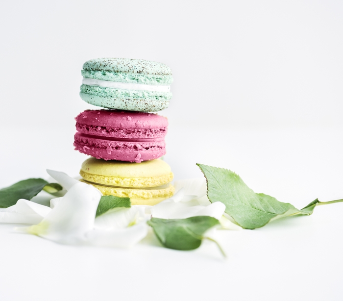 Stack of colorful macarons with petals and leaves