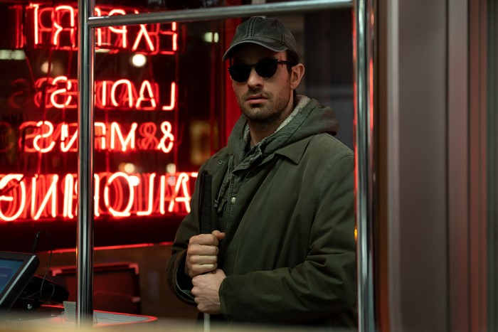 Matt Murdock in front of a neon sign