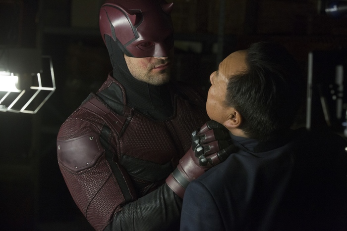 Daredevil confronts a man in a dark room