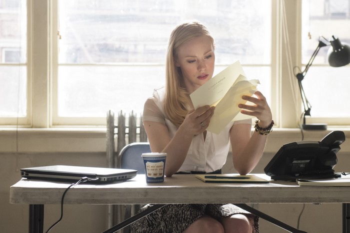 Karen Page reading documents in an office