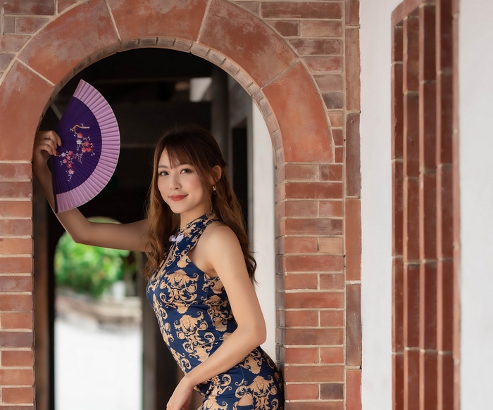 Woman in a dress holding a fan