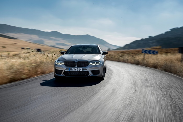 Silver BMW M5 Competition driving on a winding road