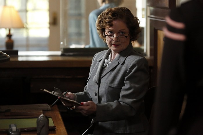 Woman in a gray suit with glasses