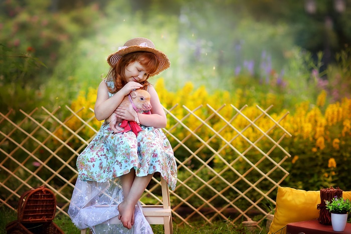 Girl in Hat Holding a Pig