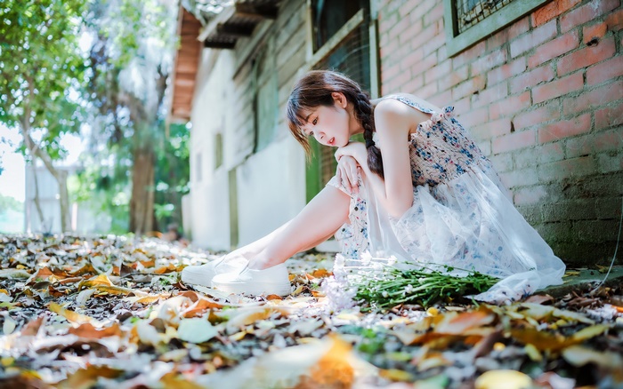 Asian woman sitting on the ground with flowers