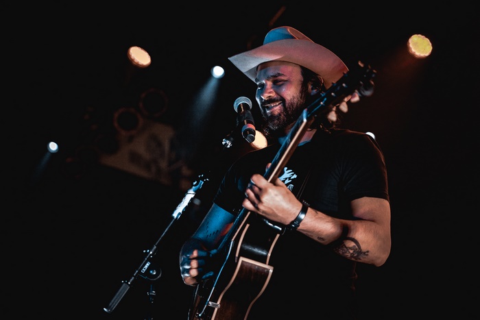 Shakey Graves performs on stage with guitar