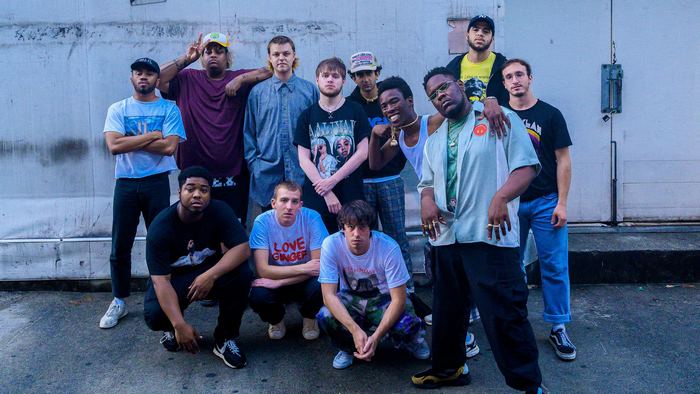 Brockhampton group posing in front of a wall