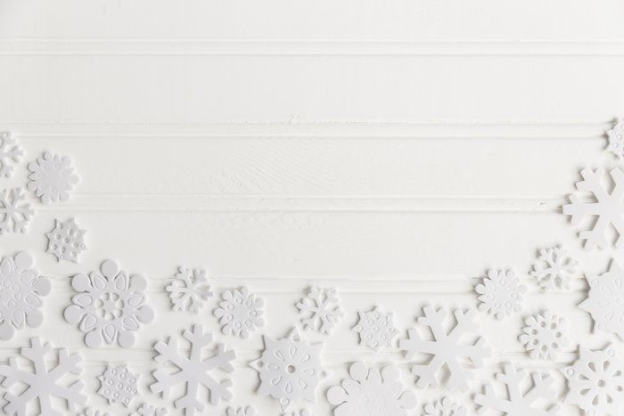 White snowflakes on a white wooden background