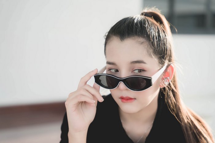 Asian girl wearing sunglasses and black shirt