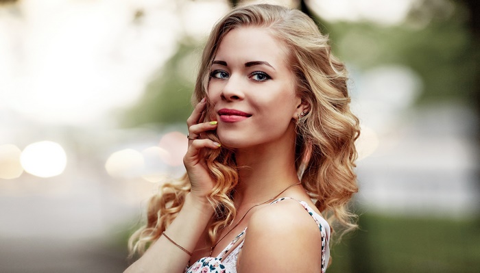 Blonde woman with curly hair in a floral dress
