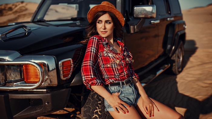 Woman in Hat and Plaid Shirt Leaning on Hummer