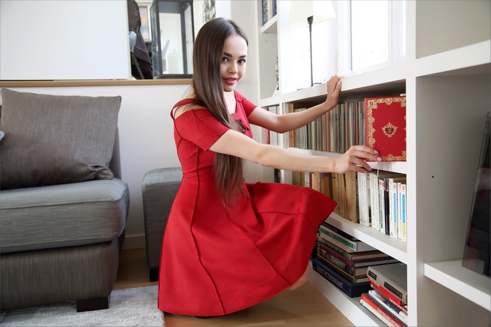 Woman in Red Dress by Bookshelf