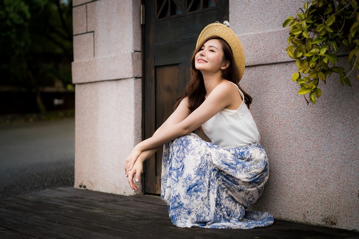 Asian woman wearing a straw hat and floral skirt