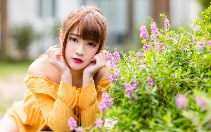 Asian woman with bangs and yellow off-shoulder top