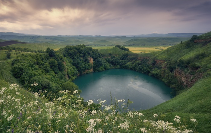 Turquoise lake surrounded by green hills and trees