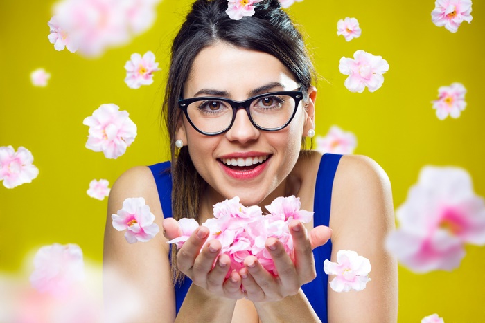 Woman with glasses holding pink flowers