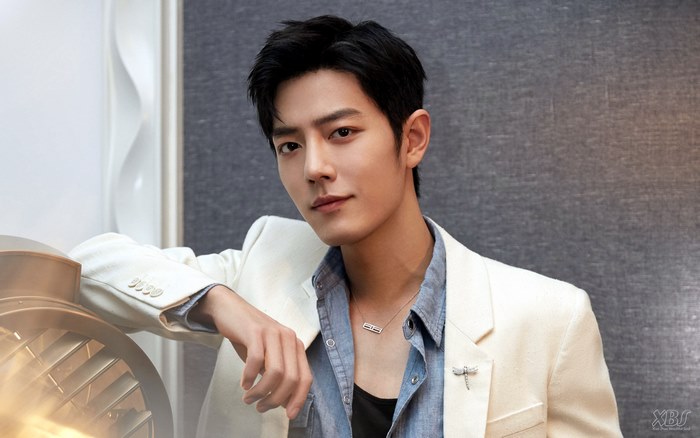Xiao Zhan in a white suit and blue shirt