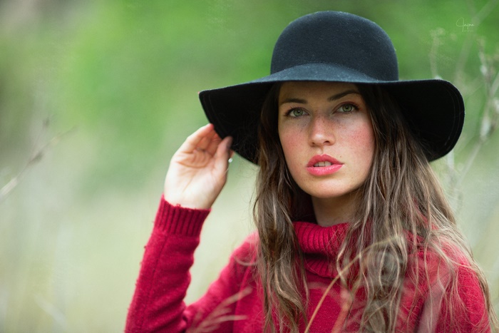 Woman in a black hat and red sweater