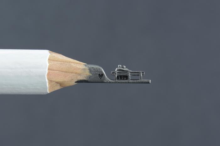 Tiny lovers bench carved on a pencil tip
