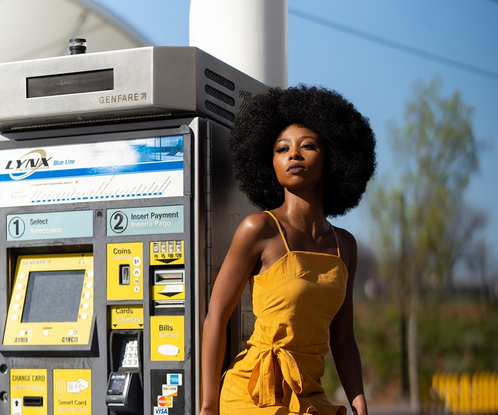 Woman in yellow dress at LYNX Blue Line ticket machine