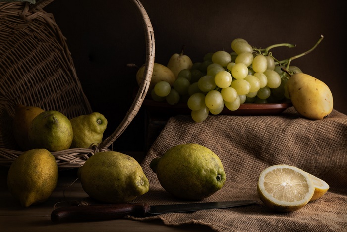 Still life with fruit in a basket and on a table