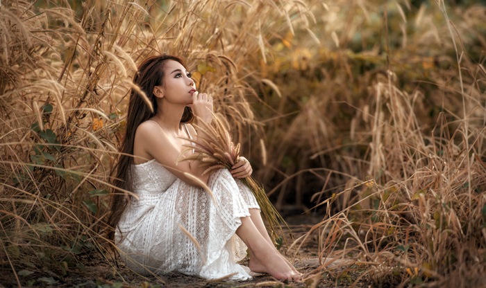Asian Woman in White Dress Sitting in Tall Grass