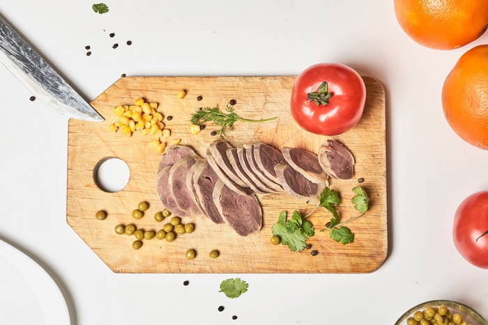 Sliced Meat and Vegetables on a Cutting Board